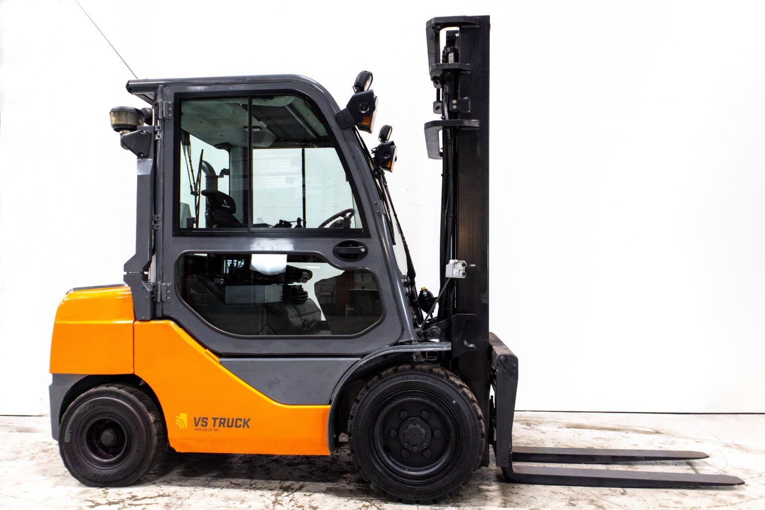 begagnad orange diesel motviktstruck med hytt från toyota